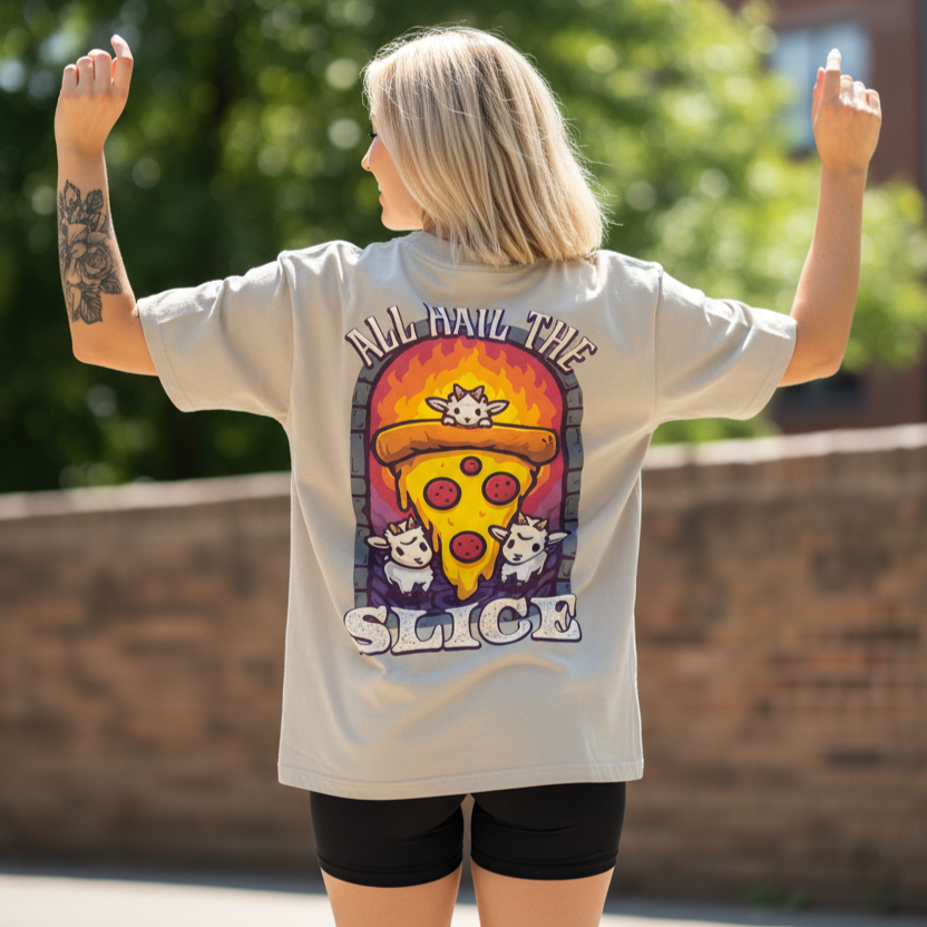 Woman wearing a graphic oversized t-shirt with a goats, pizza graphic and text, standing outdoors.