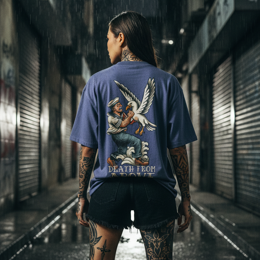 Woman wearing a blue t-shirt with a graphic back print design in a rainy alleyway